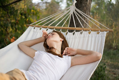 Young woman lying on hammock