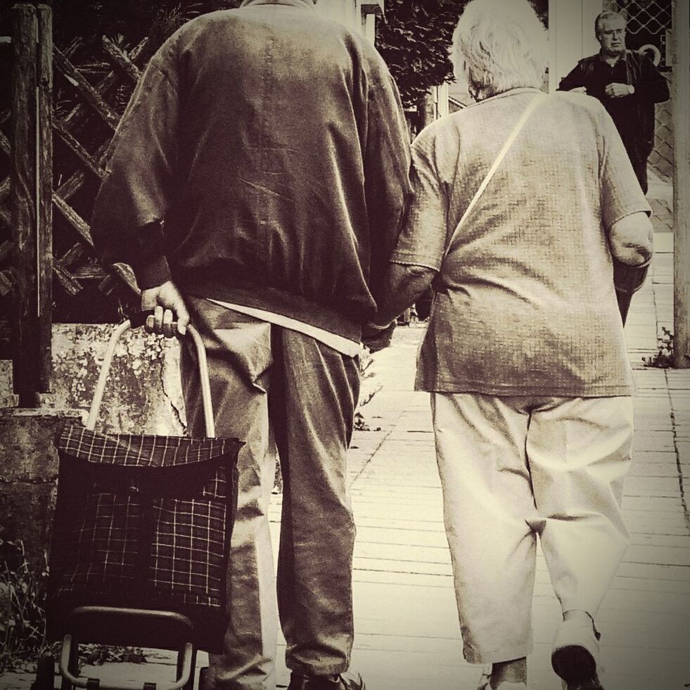 LOW SECTION OF MAN AND WOMAN WALKING ON SIDEWALK