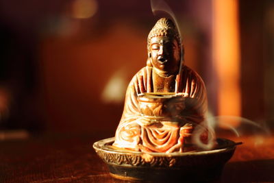 Close-up of buddha statue on table at temple