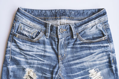 Close-up of jeans pant over white background