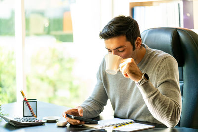 Man looking at camera while sitting on table