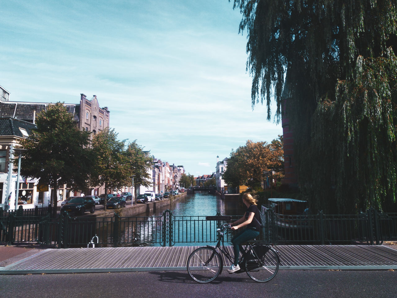 MAN RIDING BICYCLES ON STREET IN CITY AGAINST SKY