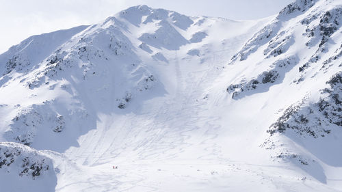 View on mountain ridge during winter, fully covered by snow with people climbing it slovakia, europe