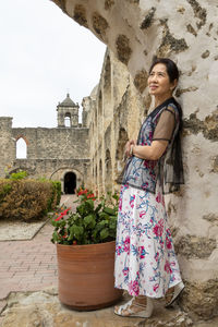 Woman standing by potted plants