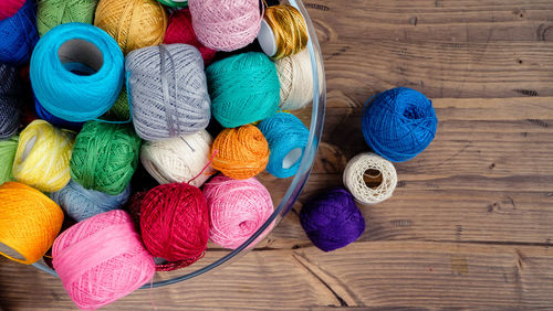 Directly above view of colorful thread balls in container on table