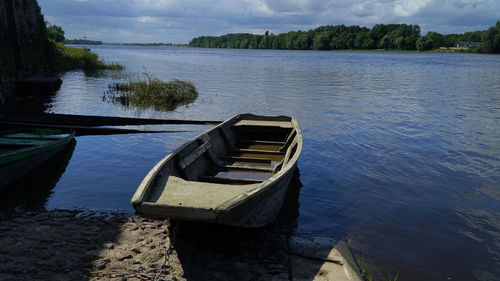 Boat moored in lake against sky