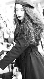 Side view of young woman wearing hat standing outdoors