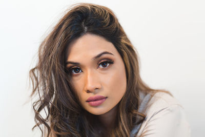 Portrait of beautiful woman against white background