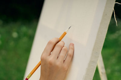 Close-up of hand holding cigarette