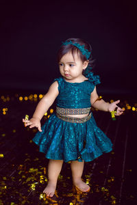 Girl in blue dress in studio with gold sequins and garland