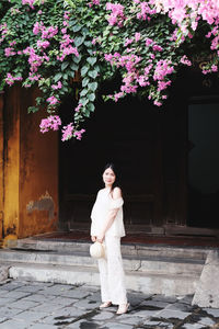 Side view of woman standing against wall