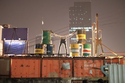 Low angle view of illuminated commercial dock against sky at night