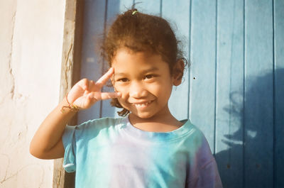 Portrait of boy standing against wall