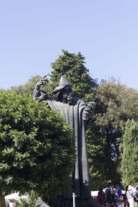 Low angle view of statue against trees