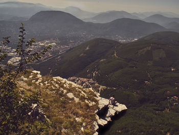 High angle view of man sitting on cliff