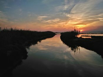 Reflection of clouds in sea at sunset