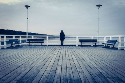 Woman standing on wooden pier