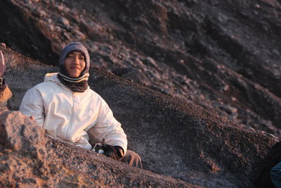 Portrait of man sitting on rock