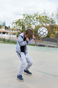 Boy playing soccer at playground