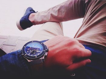 Low section of man holding clock