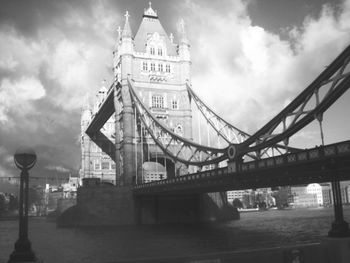 Bridge over river against cloudy sky