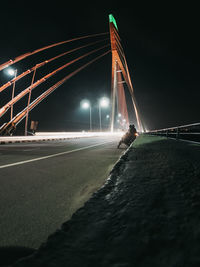 View of bridge over illuminated city at night