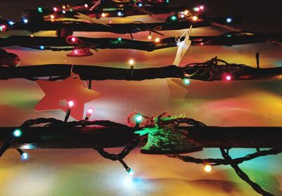 Illuminated christmas lights against sky at night