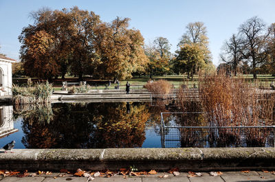 Park by lake against sky during autumn