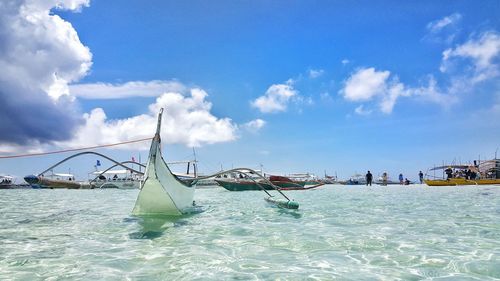 Sailboats in sea against sky