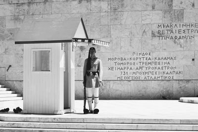 Rear view of woman standing against wall