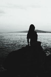 Silhouette of people looking at sea