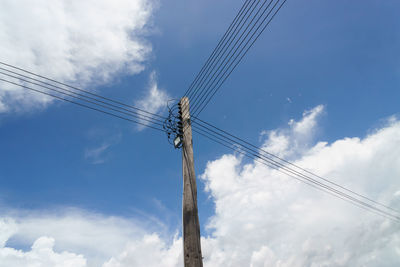 Low angle view of power line against cloudy sky