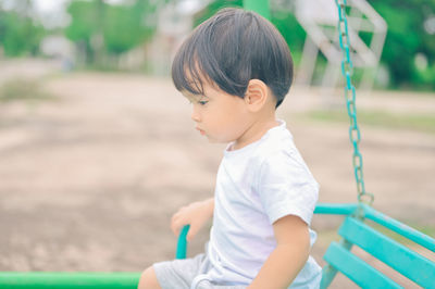 Side view of boy looking away in playground