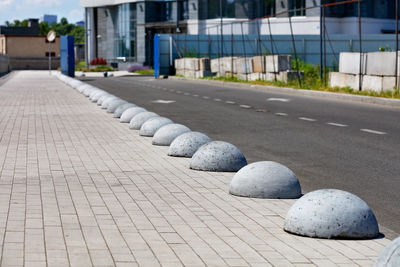 Concrete hemispheres separate the carriageway and the pedestrian walkway on the way . 