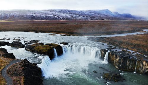 Scenic view of waterfall against sky