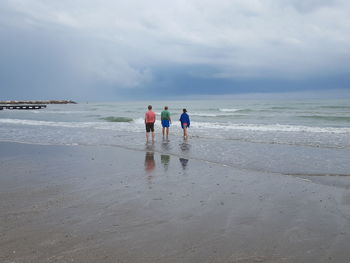 Men on beach against sky