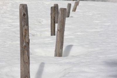 Close-up of wooden post on snow covered land