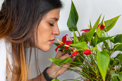 Close-up portrait of young woman holding plant