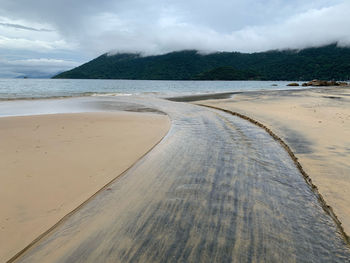 Scenic view of river flowing to the beach against sky on ilha grande 