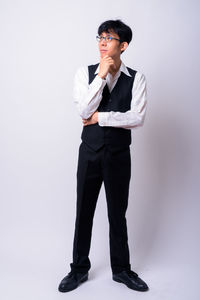 Young man standing against white background