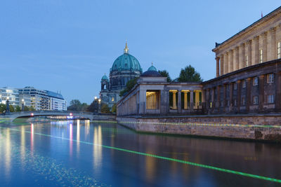 Illuminated bridge by berlin cathedral over river during sunset