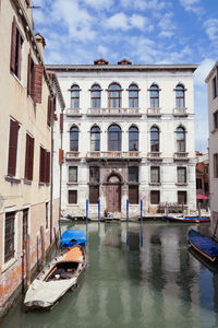 Boats moored in canal against buildings in city