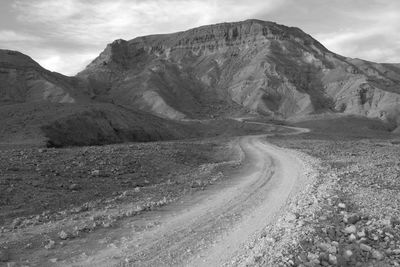 Scenic view of road by mountains against sky