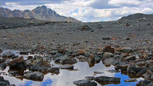 Scenic view of rocks by river against sky