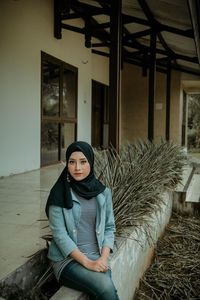 Portrait of young woman sitting outdoors