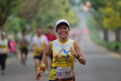 Full length of smiling man standing on road