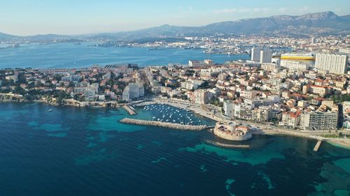 High angle view of townscape by sea against sky