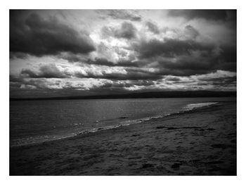 View of beach against cloudy sky