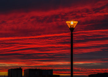 Street light against orange sky