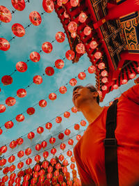 Low angle view of woman standing against red lantern